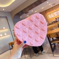 Detail of pink heart-shaped silicone bag with embossed patterns and soft texture - Pink