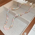 Dettaglio della collana fatta a mano con perline colorate su espositore in lino - Collana Intrecciata di Perline Colorate