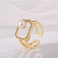 Detail van vergulde ring met vierkante zirkonia-zetting en elegante parelaccent - D-Holle Vierkante Parel