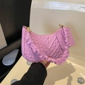 Detail of purple quilted shoulder bag featuring ruffled handle and gold hardware - Pink