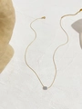 Detalle del colgante de circonita redonda en una cadena de acero de titanio dorado - Oro