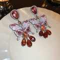 Orecchini a farfalla con cristalli rosa e ambra su un piatto in ceramica bianca - Rosso Scuro (Ago in Argento)