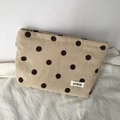 Close-up of beige corduroy polka dot bag with textured fabric and woven ATRYG label - Khaki Polka Dot Pouch