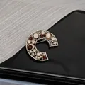 Close-up of Style C baroque brooch with colorful rhinestones on black mirror surface - Style C Retro Coffee Gold