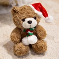 Dark brown teddy bear with Christmas hat and striped scarf on cozy white carpet - Brown Christmas Hat Bear
