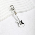 Detailed macro view of an electric guitar keychain with silver hardware and white finish - White