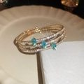 Gros plan du bracelet jonc ouvert soleil et lune avec pierres turquoise marquise - Pierre Précieuse Marquise Bleu Clair (7#)