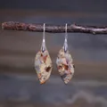 Close-up of leaf-shaped teardrop earrings with colorful stone texture on a branch - Brown Yellow White Patchwork Leaf Style (ER1015-13)