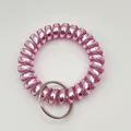 Detail of a bright pink metallic spiral wristband keyring with a silver metal ring - Metallic Light Pink