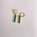 Détail de boucles d'oreilles dorées avec cinq pierres de zircon vert ovale sur du cuir - Or + Vert (DEK1398)