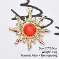 Detailed macro view of gold-plated sunburst pendant with red gemstone, size 2.7x3.0cm - Jelly Red