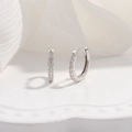 Macro view of sterling silver hoop earrings with cubic zirconia on white fabric - 14mm / Silver
