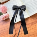 Elegant large black silk ribbon bow hair clip with long streamers on a romantic floral background - Black