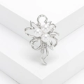 Elegante broche floral de plata con perlas blancas y hojas caladas sobre base blanca - Plateado