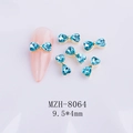 Golden bow nail charms with light blue heart stones on pink nails, size 9.5x4mm - Aqua Blue Gold Base Bow (8064)