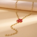 Dettaglio del ciondolo a fiore in smalto rosso su catena a sfere dorate in stile retrò - Rosso