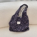Detail of black seersucker floral tote bag with 3D texture on white fleece sofa - Black with Pink Floral