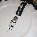 Détail d'un serre-tête en velours avec fleurs argentées, strass et pampilles à franges - No.24 Pince BB - Noir - Style Mat