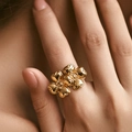 Macro detail of the 18K gold plated double flower design ring on a hand model - Adjustable Open / 3D Four-Petal Overlapping Flower (KR0143)
