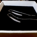 Detalle de pendientes de cadena de plata con circonitas pavé sobre fondo de joyero - Plateado
