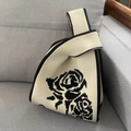 Knit tote bag featuring black rose floral patterns on a cream background with knot handle - Retro Rose Beige