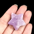 Polished 30mm purple natural lepidolite star stone held in hand for size visualization - Lepidolite