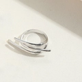 Detailed view of a silver double-layered minimalist ring on a textured surface - Three-layer Style