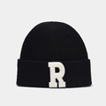 Détail du bonnet en maille noire avec écusson en forme de lettre R blanche en peluche - Noir