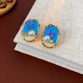 Details von Vintage-Ohrringen mit blauem Emaille, lila Schmetterling und Perlen auf Leinen - Ovaler Schmetterling Blauer Perlenstil / Gold Blau Lila Weiß