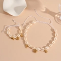 Detail of seashell jewelry set with golden sea creature charms on beige surface - White Rope Fish Set