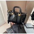 Détail d'un sac à main en cuir verni noir avec dorures et bandoulière réglable - Noir