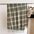 Detail of soft plaid scarf with green and orange fringe hanging on a metal hanger - Green Orange & White Plaid (WT153-6)