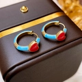 Detail von goldenen Creolen mit blauer Emaille und einem kleinen roten Herzanhänger - Herz-Stil / Blau