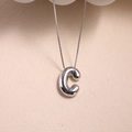Polished silver letter C pendant with a 3D balloon texture on a beige background - Letter C - Silver