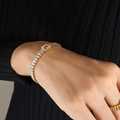 Elegante bracciale dorato con zirconi rettangolari e una grande pietra centrale a gradini - Bracciale Bianco