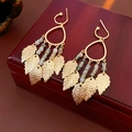 Détail de boucles d'oreilles à franges feuille avec monture dorée et perles colorées - Or