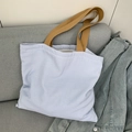 Detail of blue striped canvas tote bag texture with brown handles on a sofa - Blue Stripe Khaki Strap