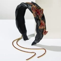 Detalle de diadema de cuero negro con mariposas de pedrería dorada y cadena de borla larga - Negro