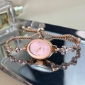 Detail of rose gold oval watch featuring pink rhinestones and leaf-shaped metal strap - Pink