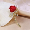 Makroaufnahme einer roten Rosenbrosche mit goldenem Stiel, Strasssteinen und Tropfenanhänger - 1679 Rose