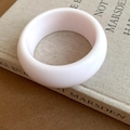 Minimalist thick round white resin bangle bracelet shown on a beige book cover - Minimalist Solid Style / White