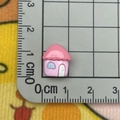 Close-up of a mini pink resin house charm showing 1cm size measurement on a scale - Mini House