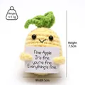 Macro shot of 7.5cm handmade crochet pineapple doll with positive message card - Round Pineapple with Fine Card