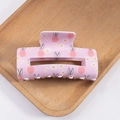 Matte pink hair claw clip with rabbit and daisy print for women on wooden tray - Sakura Pink Hand-drawn Rabbit
