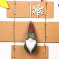 Detail of a Christmas gnome ornament featuring a green knitted hat with a red reindeer pattern - Green Style B