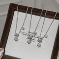 Detailed view of silver four-leaf clover and solitaire diamond necklaces on a velvet tray - With Chain / Silver Clover Necklace