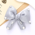 Close-up of a grey satin bow accessory embellished with sparkling multi-shaped rhinestones - Gray
