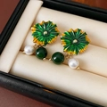Makro-Detail von Emaille-Blumenohrringen mit weißen Perlen und grünen Perlen in einer Box - 58# Silberne Nadel Emaille Perlen Lotusblatt Ohrstecker