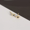 Detailed close-up of gold evil eye stud earrings with blue stones and white zircon - Gold