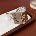 Gedetailleerde macro-opname van brede zilveren armband met vloeiende textuur - Onregelmatige Gehamerde Stijl / Zilver